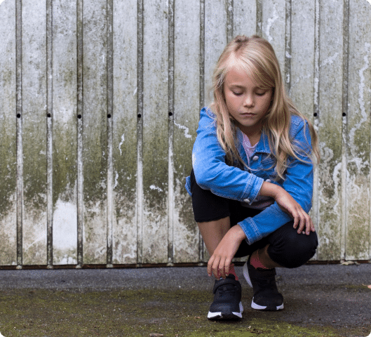 A girl crouching on the ground.