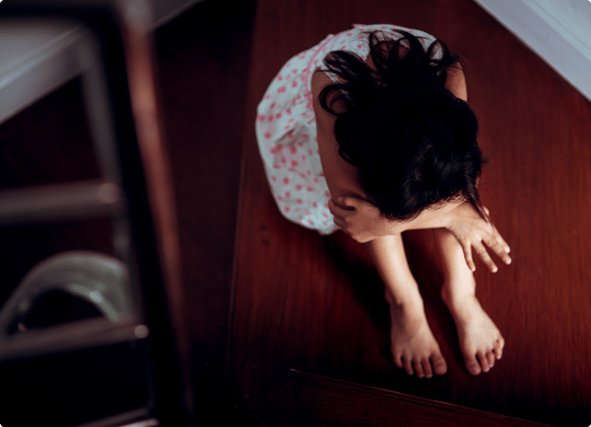 A girl sitting on the floor.